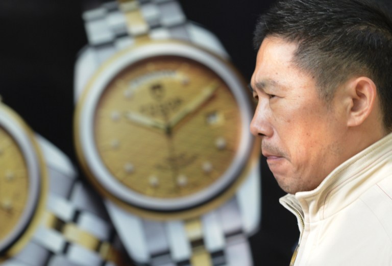 图片:美国彭博社网站9月23号刊登文章说,习近平开展的反腐运动,令澳门赌场、香港奢侈品以及中国各大城市的高端酒店餐馆的收入受到了重创。图为2013年12月19日的上海街头,一名行人经过一家奢侈品店。(法新社)