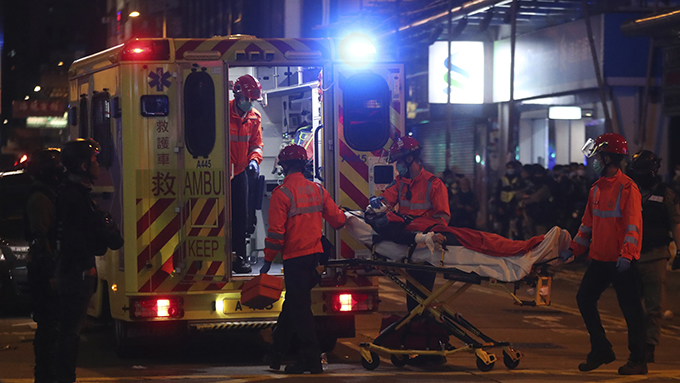 2020年1月27日,香港医护人员在旺角将一名抗议者送上救护车。(美联社)