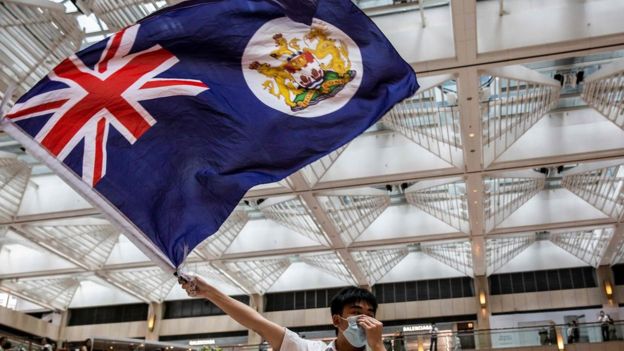 香港中环某购物商场内一名“反送中”示威者挥舞港英年代旗帜（1/6/2020）