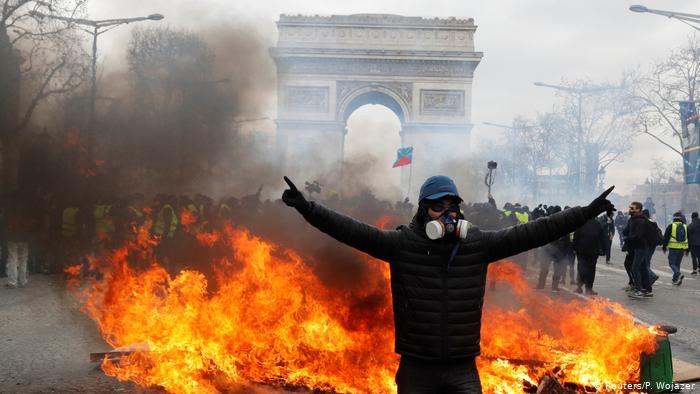 A protester stands in front of burning barricade during a demonstration by the yellow vests movement in Paris, France, March 16, 2019. (REUTERS/Philippe Wojazer)