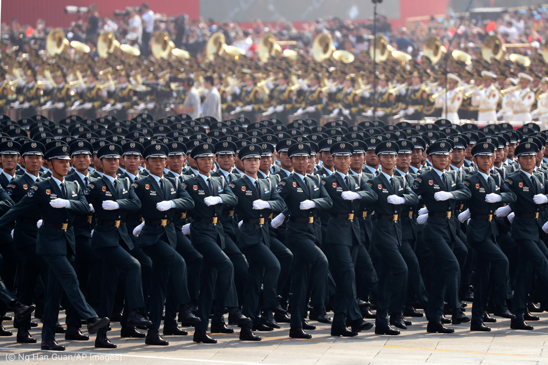 Chinese soldiers marching, with a band in the background (© Ng Han Guan/AP Images)
