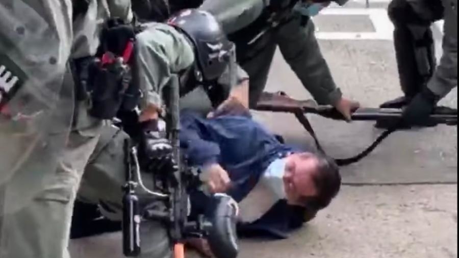 两名警察日前镇压行动中将一名老伯摔在地上双手反绑在后。但警方否认这是暴力,还派出“中国代表”在联合国反控遭到暴徒挟持。