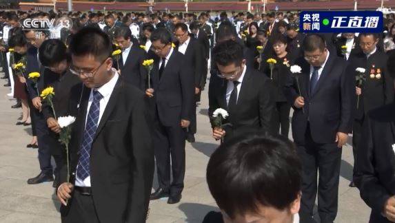 參加默哀的1名男子竟不斷轉動、把玩手上的花朵,在默哀隊伍中相當顯眼。(圖取自央視微博) 參加默哀的1名男子竟不斷轉動、把玩手上的花朵,在默哀隊伍中相當顯眼。(圖取自央視微博)